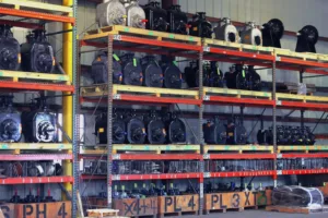 Rows of industrial pumps neatly arranged on shelves in a well-organized warehouse, showcasing various types of industrial pumps including centrifugal pumps, positive displacement pumps, and other industrial equipment. The warehouse setting highlights the extensive inventory and quality of products offered by Arroyo Process Equipment.