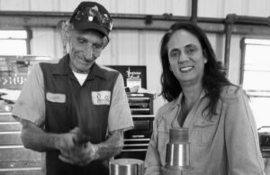 Arroyo President, Diane Schleicher, in the shop with an employee, who is repairing a pump.