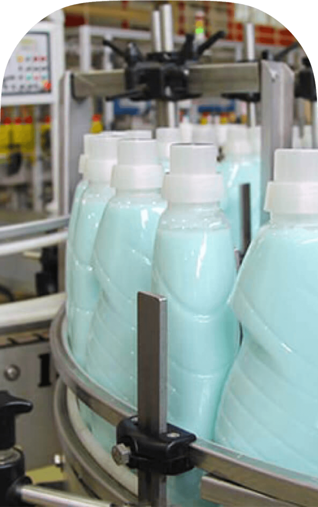 Close-up of liquid soap bottles on a production line, showcasing efficient chemical pump use in soap manufacturing.
