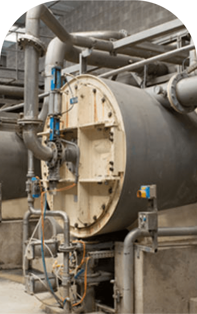 Close-up of industrial machinery and piping used in the handling and processing of caustic substances.